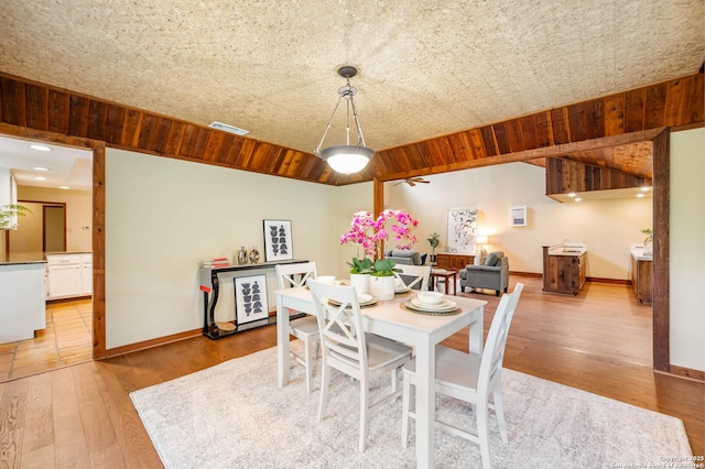 dining space featuring baseboards, wood finished floors, and visible vents