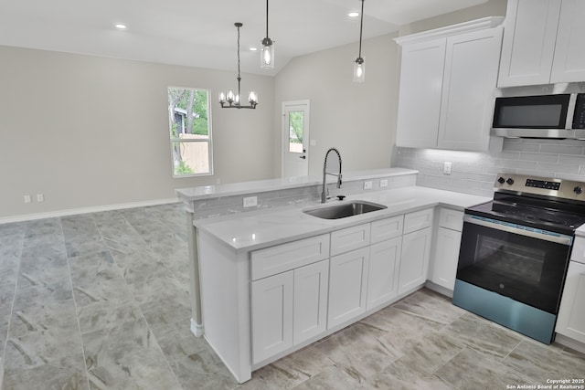 kitchen featuring appliances with stainless steel finishes, a peninsula, light countertops, and a sink