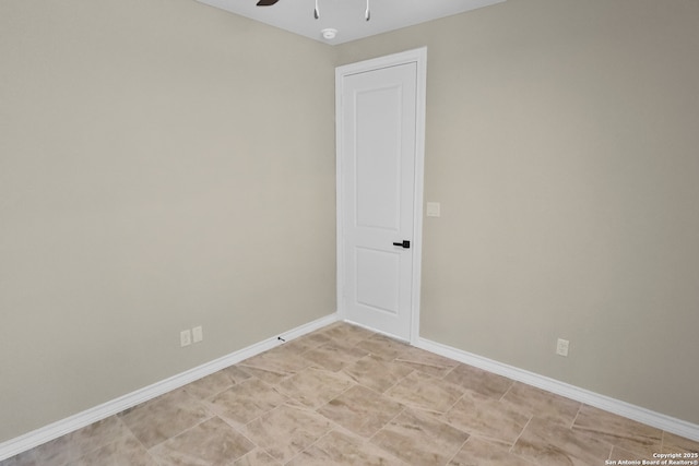spare room featuring baseboards and ceiling fan