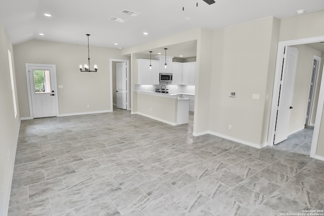 unfurnished living room with visible vents, recessed lighting, baseboards, and ceiling fan with notable chandelier