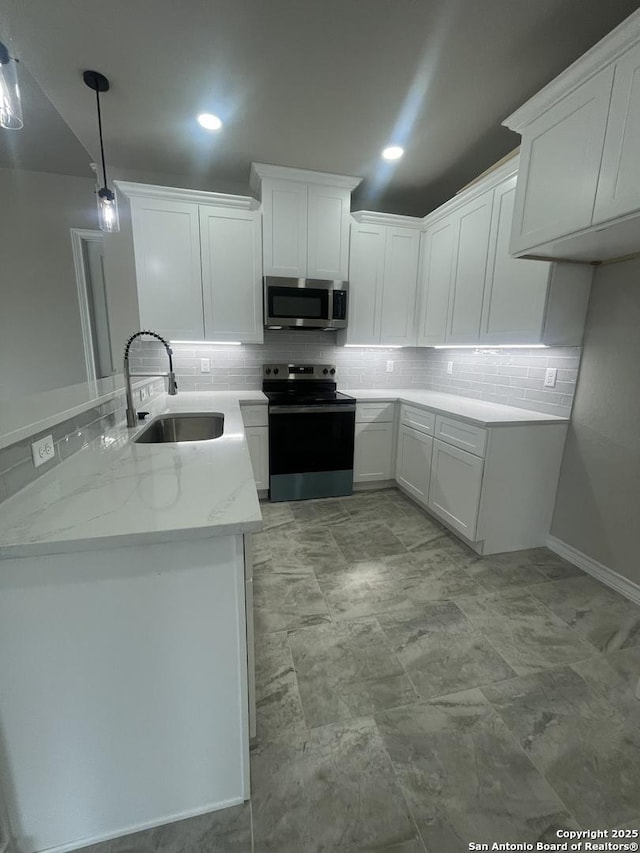 kitchen featuring white cabinets, stainless steel appliances, decorative backsplash, and a sink