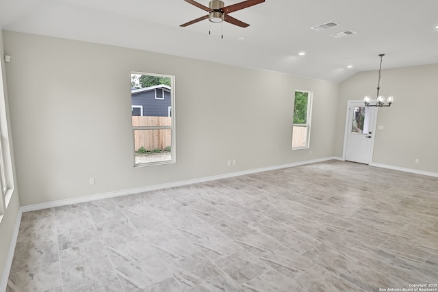 spare room featuring ceiling fan with notable chandelier, visible vents, and a wealth of natural light