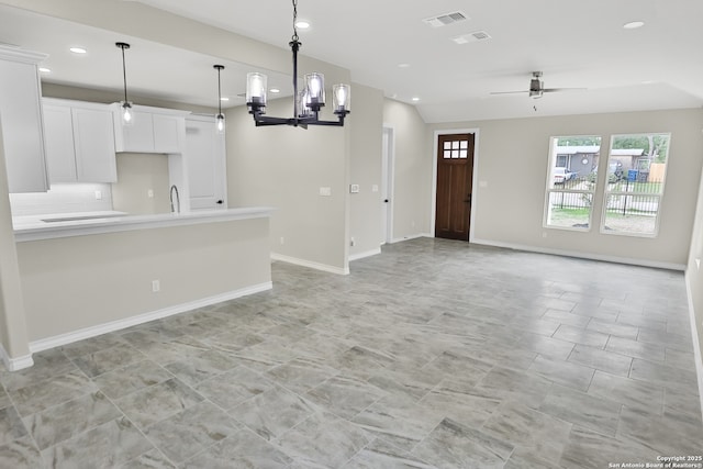 unfurnished living room with visible vents, recessed lighting, baseboards, and ceiling fan with notable chandelier