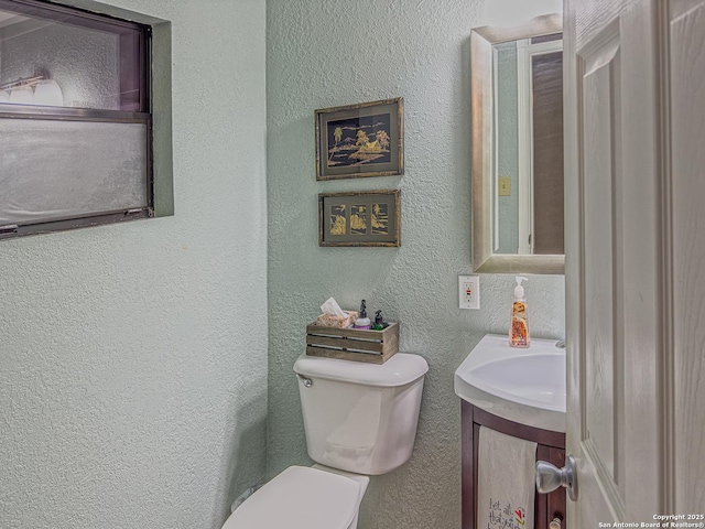702 Schubert, Fredericksburg, TX 78624 - half bathroom with vanity, a textured wall, and toilet