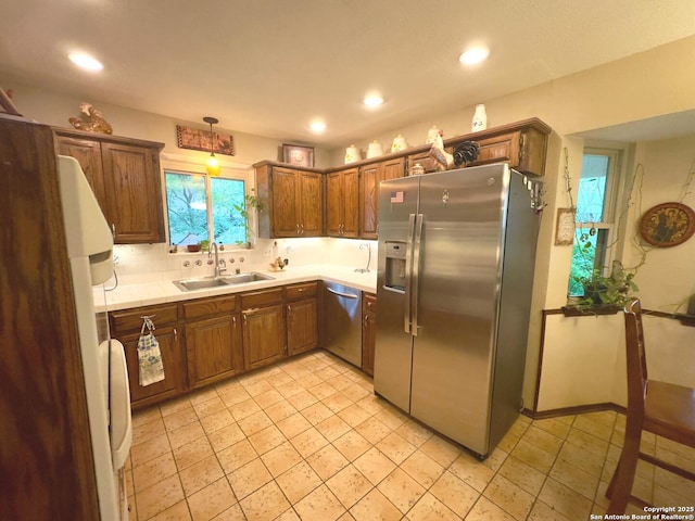 kitchen with brown cabinets, recessed lighting, a sink, and appliances with stainless steel finishes