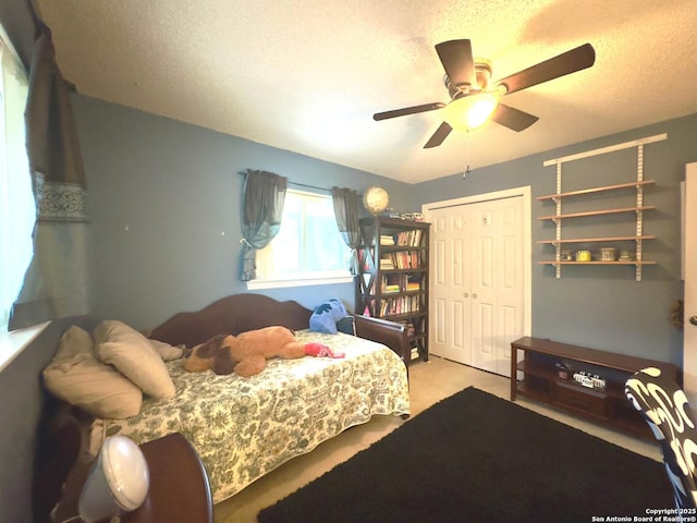 carpeted bedroom featuring a ceiling fan, a textured ceiling, and a closet