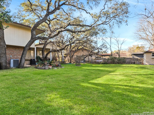 view of yard with fence and central AC