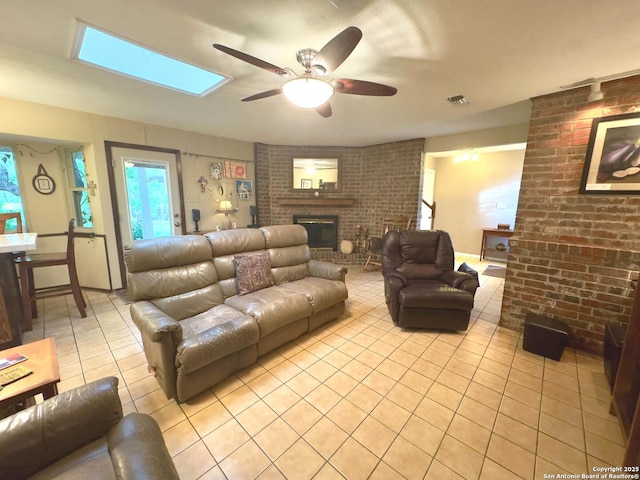 living area featuring light tile patterned floors, brick wall, a ceiling fan, and a brick fireplace