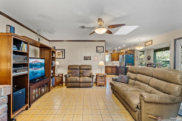 living room with light tile patterned floors, crown molding, a ceiling fan, and a skylight
