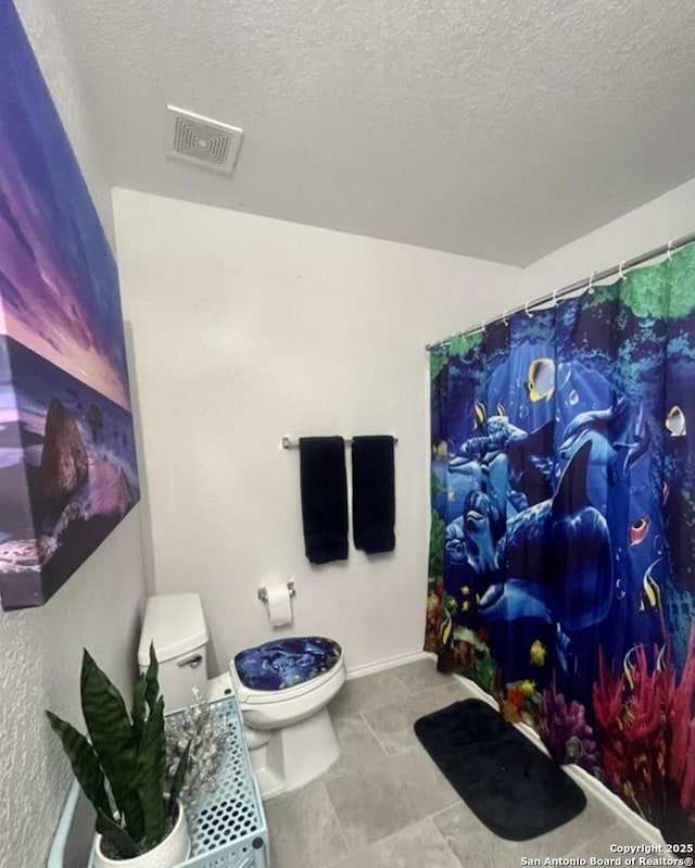 bathroom with a textured ceiling, curtained shower, visible vents, baseboards, and toilet
