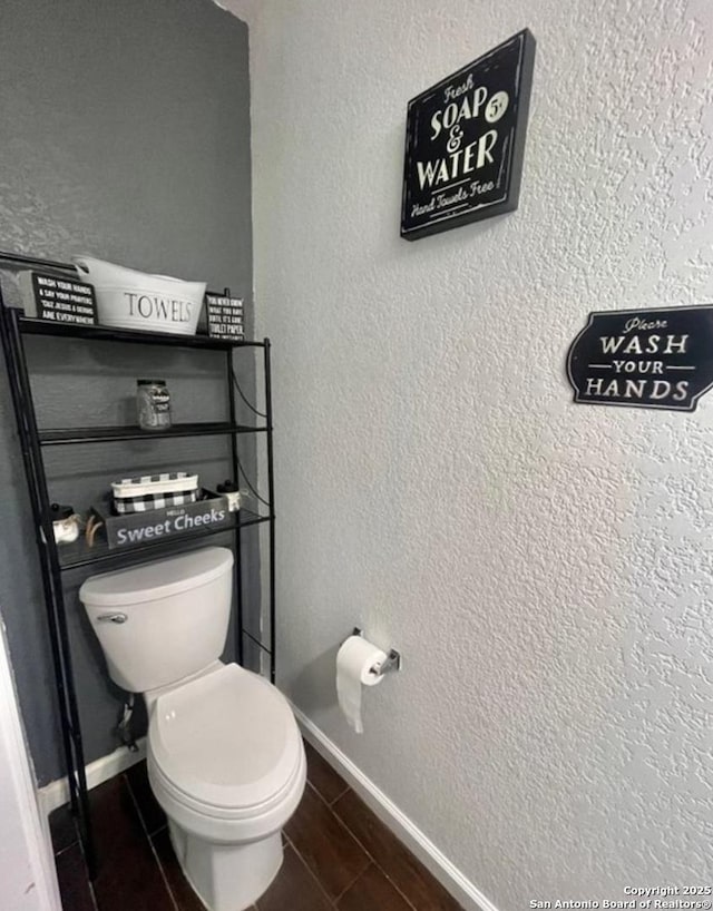 bathroom with toilet and baseboards
