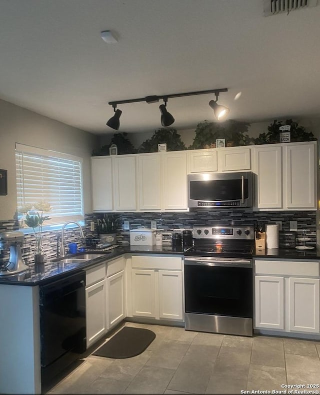 kitchen with dark countertops, a sink, appliances with stainless steel finishes, and tasteful backsplash