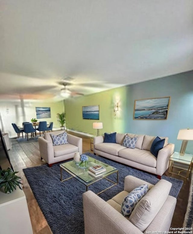 living area with wood finished floors and a ceiling fan
