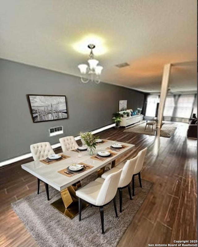 dining room with dark wood finished floors, baseboards, and an inviting chandelier