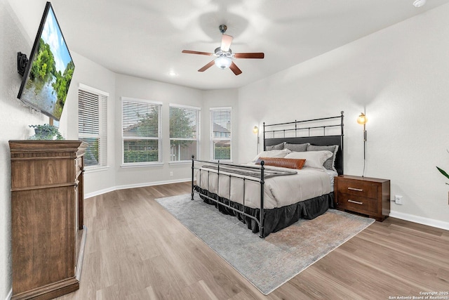 bedroom featuring baseboards, ceiling fan, and wood finished floors