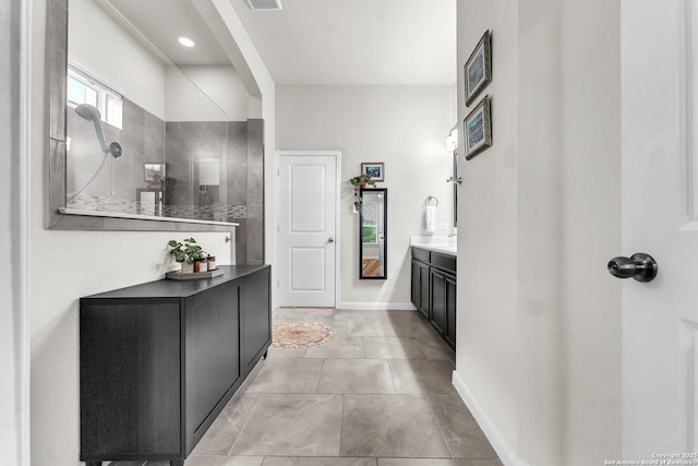 bathroom with a walk in shower, baseboards, visible vents, and vanity