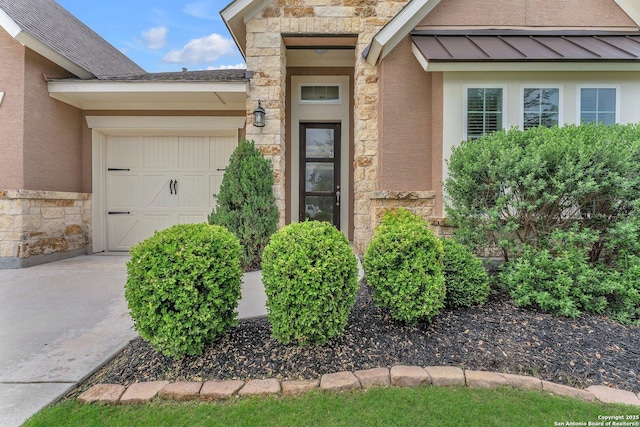 view of exterior entry featuring a garage, stucco siding, stone siding, and a standing seam roof