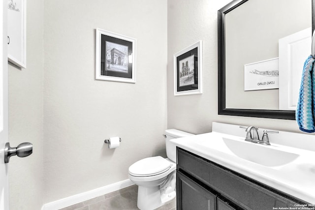 bathroom with toilet, baseboards, and vanity