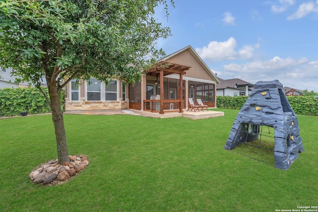 rear view of property featuring a lawn, a patio, and stone siding