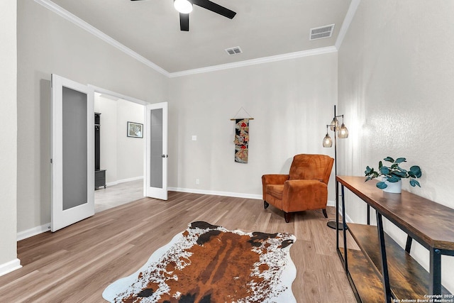 sitting room featuring visible vents, ornamental molding, wood finished floors, ceiling fan, and french doors