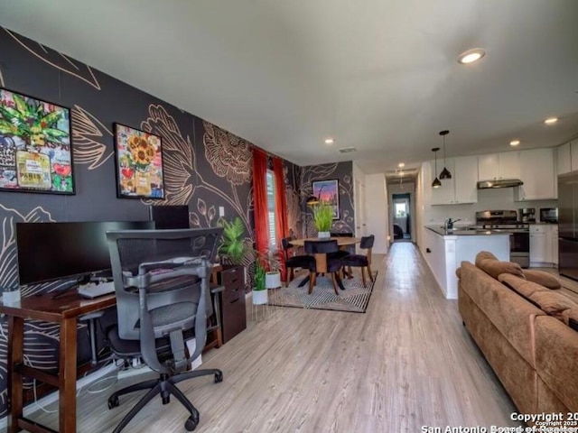 office space featuring an accent wall, recessed lighting, light wood finished floors, and wallpapered walls