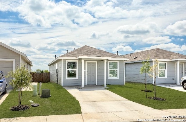ranch-style house featuring fence, a front lawn, and concrete driveway