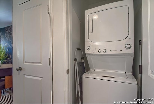 laundry room with stacked washer / drying machine and laundry area