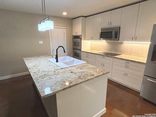 kitchen featuring a sink, tasteful backsplash, white cabinetry, baseboards, and appliances with stainless steel finishes