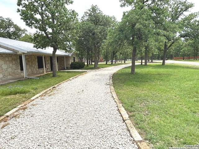 view of community with a lawn and driveway