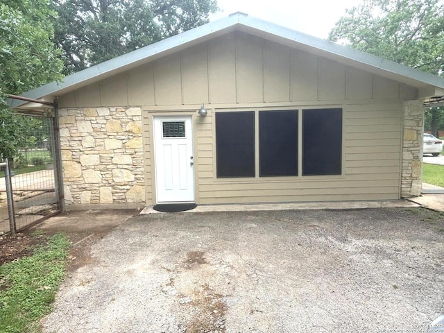 rear view of house featuring stone siding