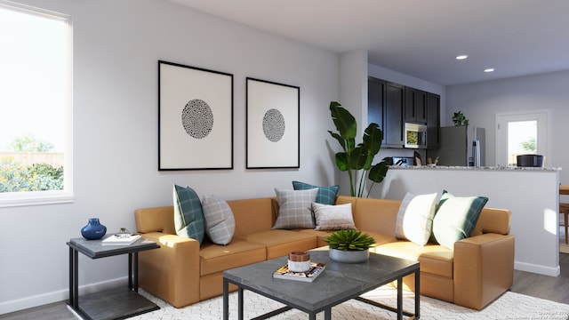 living room featuring recessed lighting, baseboards, and light wood-style floors