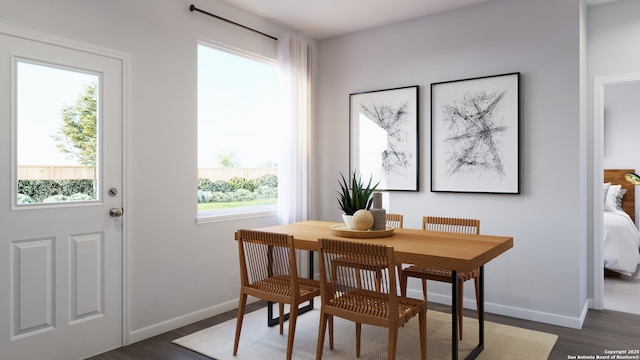 dining space featuring dark wood-style floors and baseboards