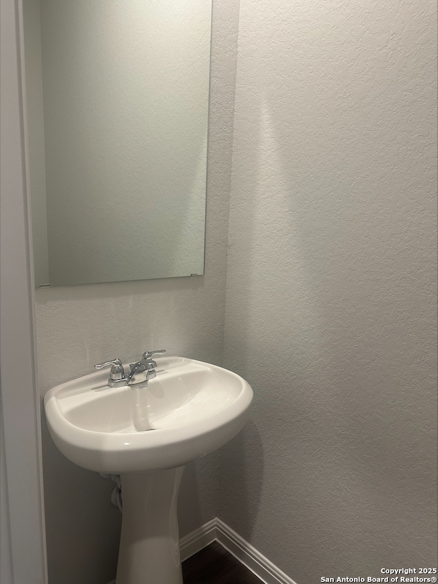 bathroom featuring baseboards and a textured wall