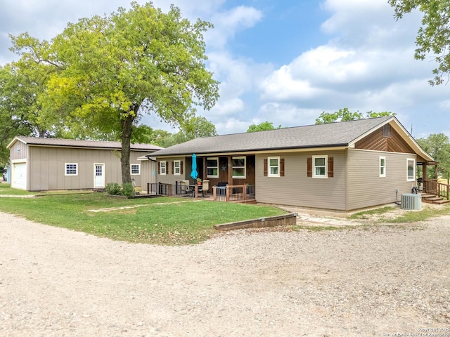 rear view of house featuring central AC unit and a lawn