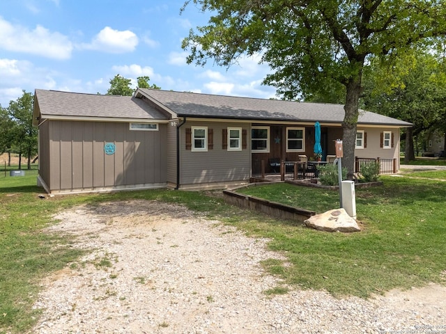 back of house featuring driveway and a yard