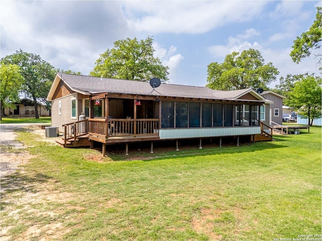 rear view of property featuring a lawn, central AC, a wooden deck, and a sunroom