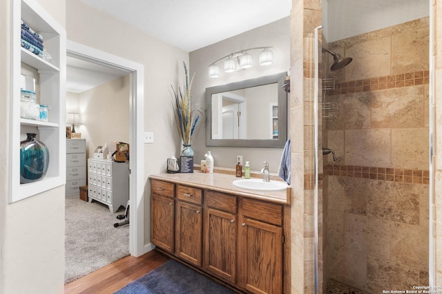 full bathroom with wood finished floors, vanity, and a stall shower