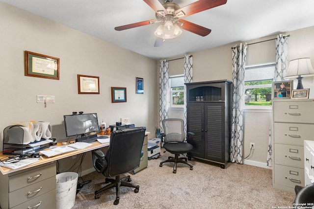 home office with a ceiling fan, light colored carpet, and baseboards