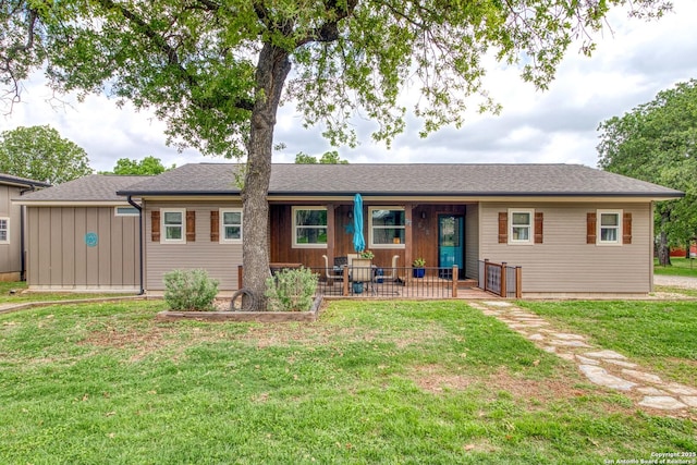 back of house featuring covered porch and a yard