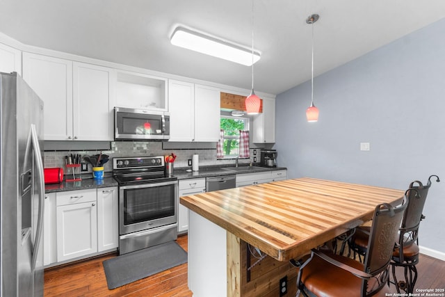 kitchen with appliances with stainless steel finishes, white cabinetry, open shelves, and dark wood-style floors