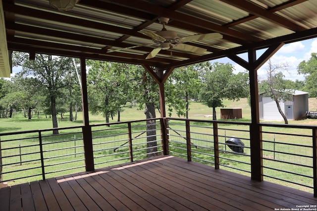 97 Segner, Fredericksburg, TX 78624 - wooden deck with ceiling fan, an outdoor structure, a storage unit, a lawn, and view of wooded area