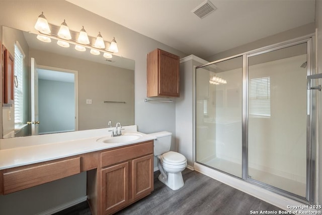 bathroom featuring a shower stall, visible vents, toilet, wood finished floors, and vanity