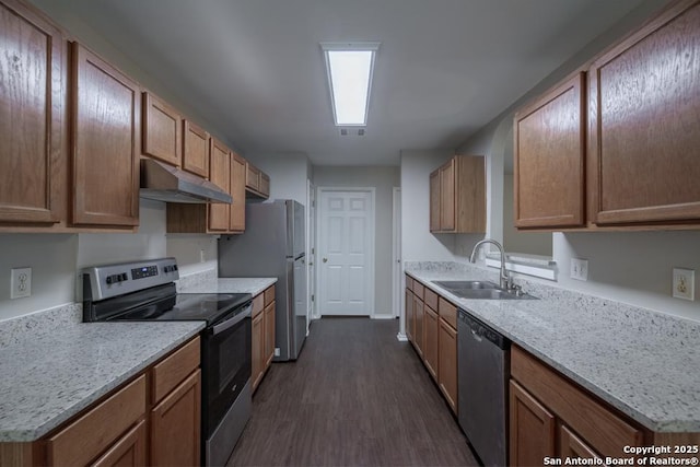 kitchen with stainless steel appliances, under cabinet range hood, a sink, visible vents, and dark wood-type flooring
