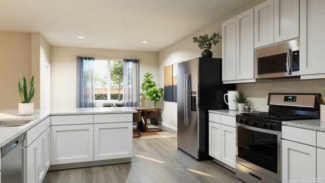 kitchen with recessed lighting, stainless steel appliances, tasteful backsplash, light wood-type flooring, and white cabinets
