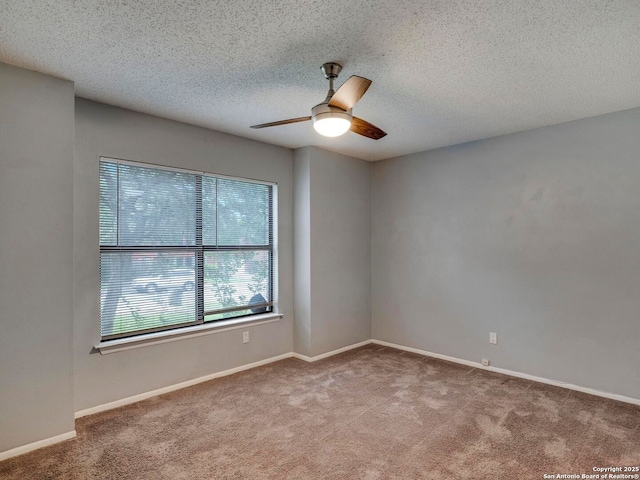 carpeted spare room with a textured ceiling, ceiling fan, and baseboards