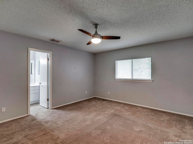carpeted empty room with baseboards, visible vents, a ceiling fan, and a textured ceiling