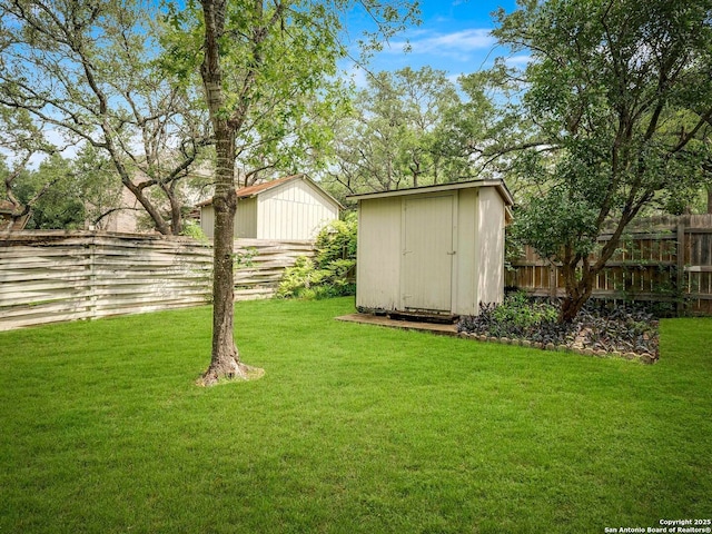 view of yard with a storage unit, fence private yard, and an outbuilding