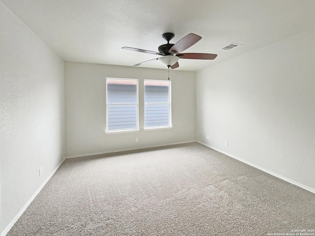 spare room featuring baseboards, visible vents, a ceiling fan, and carpet floors
