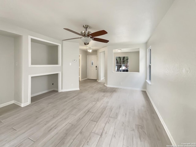 unfurnished living room with ceiling fan, light wood-type flooring, and baseboards