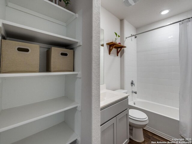 full bathroom featuring recessed lighting, wood finished floors, shower / bathtub combination with curtain, toilet, and vanity
